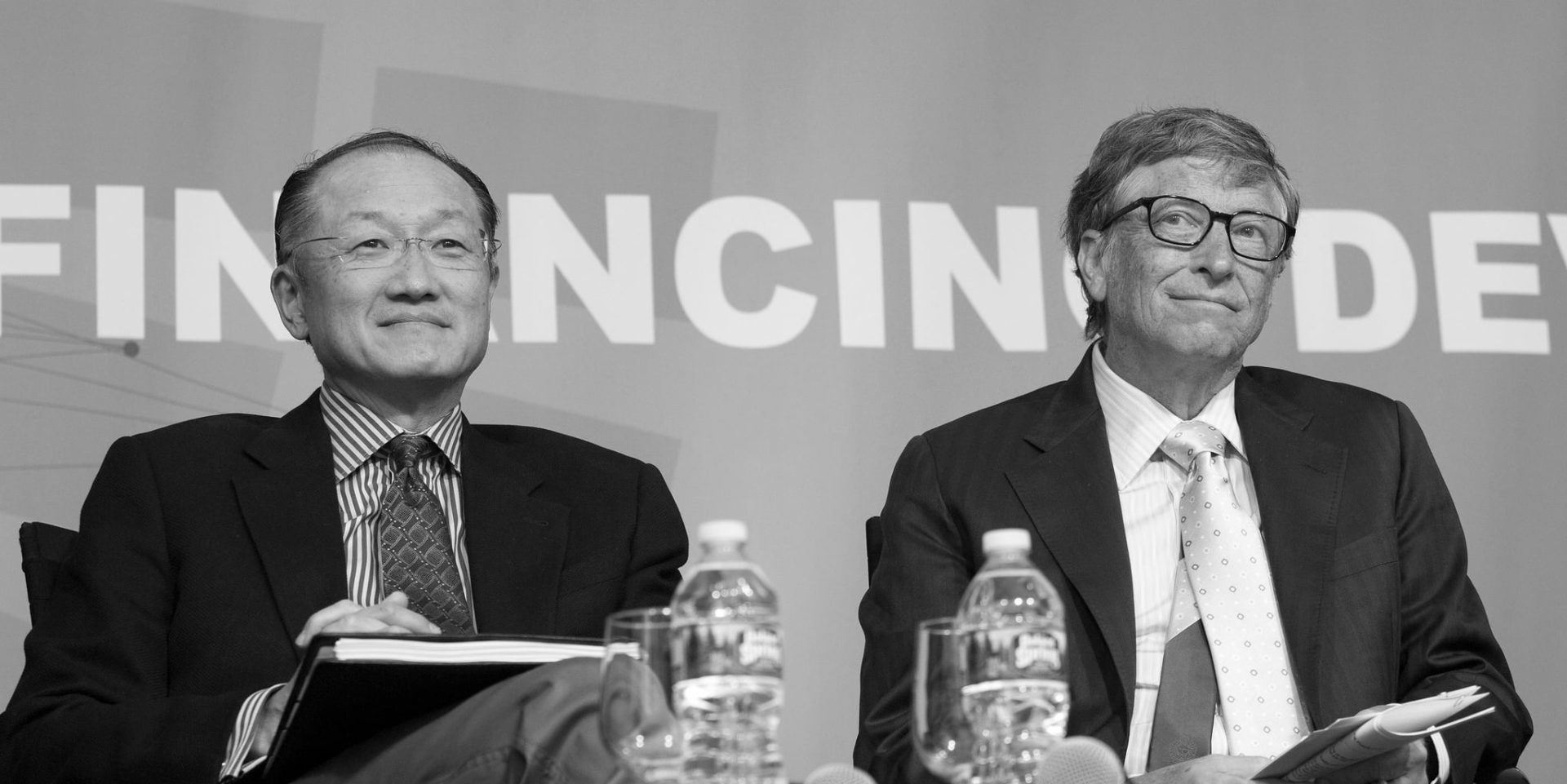 Former World Bank President Jim Yong Kim sitting next to Bill Gates, the two of them are smiling